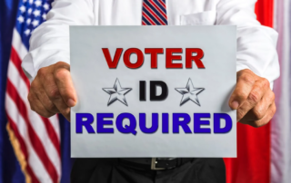 Man holding "Voter ID Required" sign