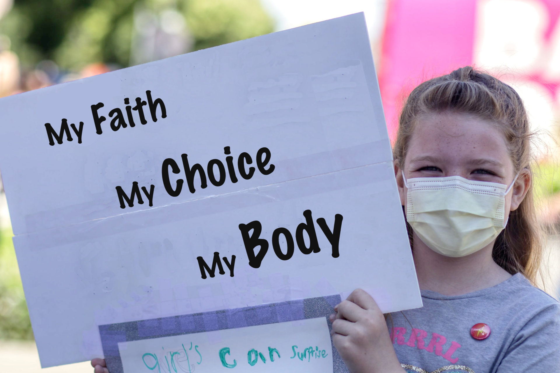 Girl holding sign that says, "My Faith, My Choice, My Body"