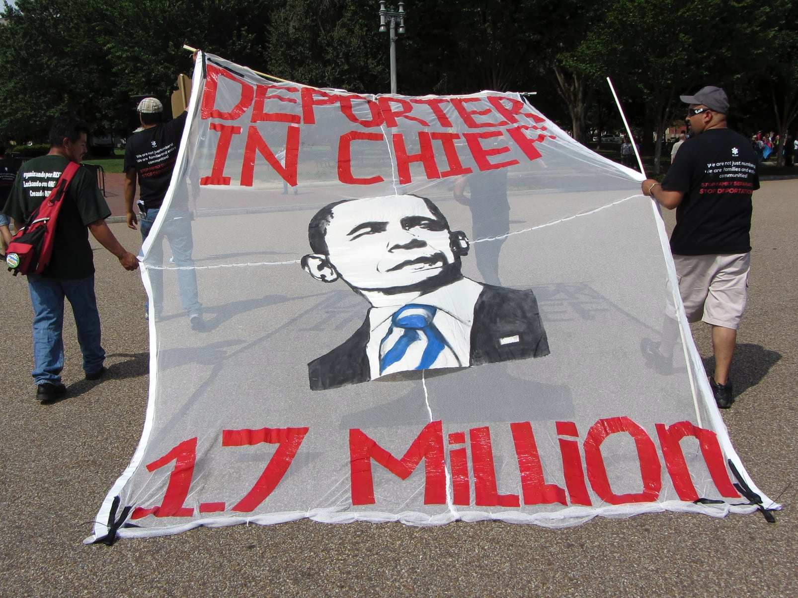 Poster says "Deporter in Chief" with image of President Obama's face